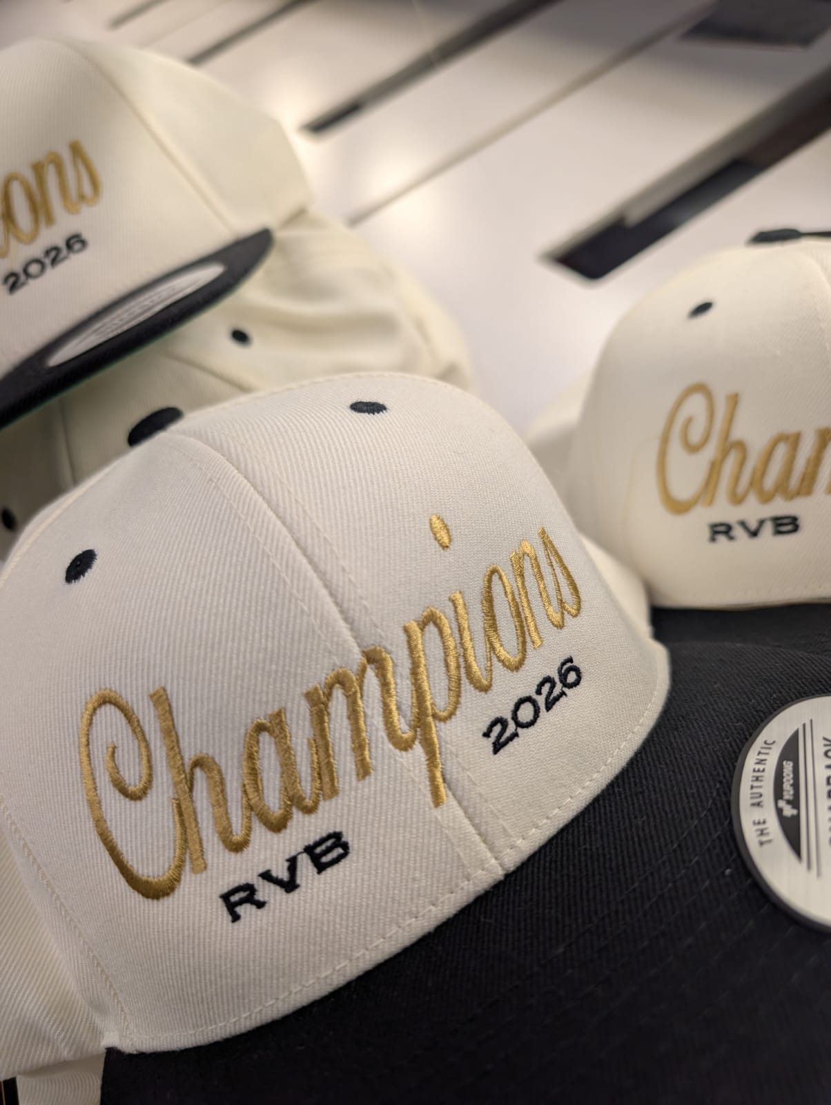 Casquettes snapback écrues brodées « Champions 2026 » en fil doré