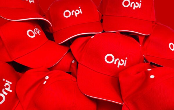 Casquettes rouges brodées d'un logo blanc, empilées