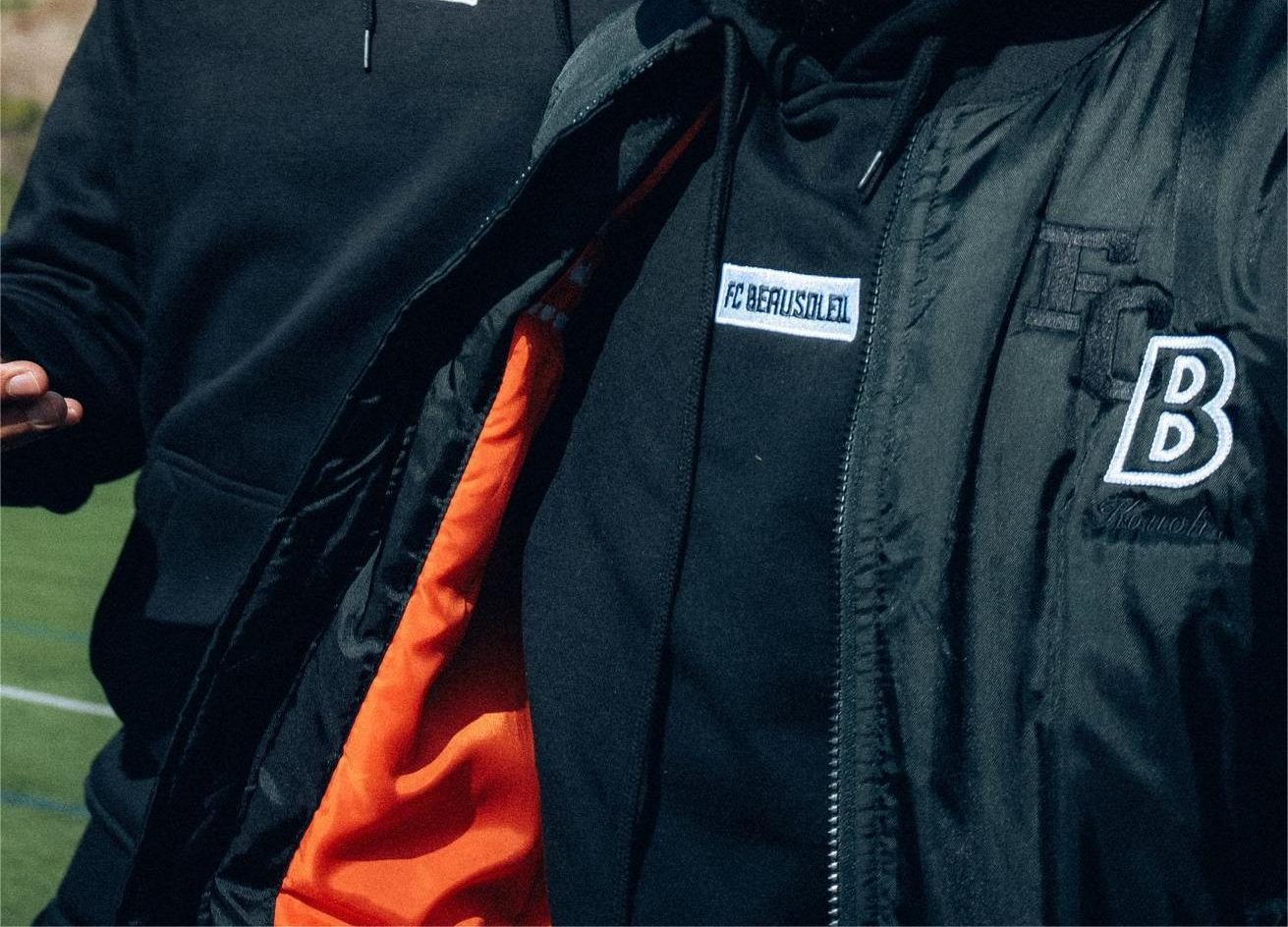 Sweats et bomber bleu marine brodés aux couleurs d'un club de football, portés par l'équipe